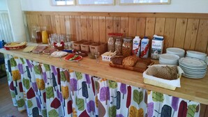 Un tavolo per buffet con diversi cibi, tra cui pane, uova e salse.