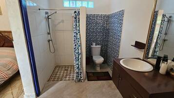 A bathroom with a shower, toilet, and sink.