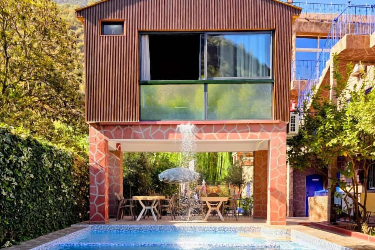 A modern two-story building with a swimming pool in front.