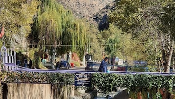 A river with rocks and a bridge with tables and chairs.