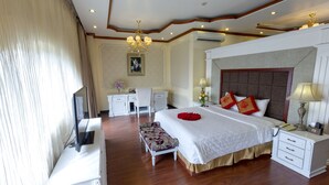A hotel room with a large bed, bedside tables, a desk, and a chair.