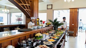 A buffet area with a variety of dishes, a coffee station, and a view of the outside.