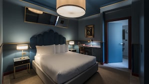 Een moderne hotelkamer met een groot bed, bedlampjes, een bureau en een spiegel.