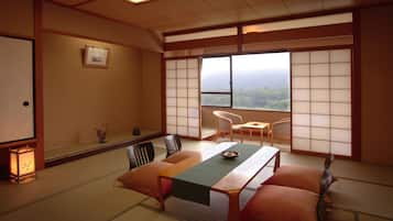 Ein traditioneller japanischer Raum mit Tatami-Bodenbelag, einem niedrigen Tisch und Shoji-Schirmwänden.