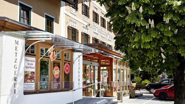 Un restaurant avec une terrasse et un menu affiché à l’extérieur.
