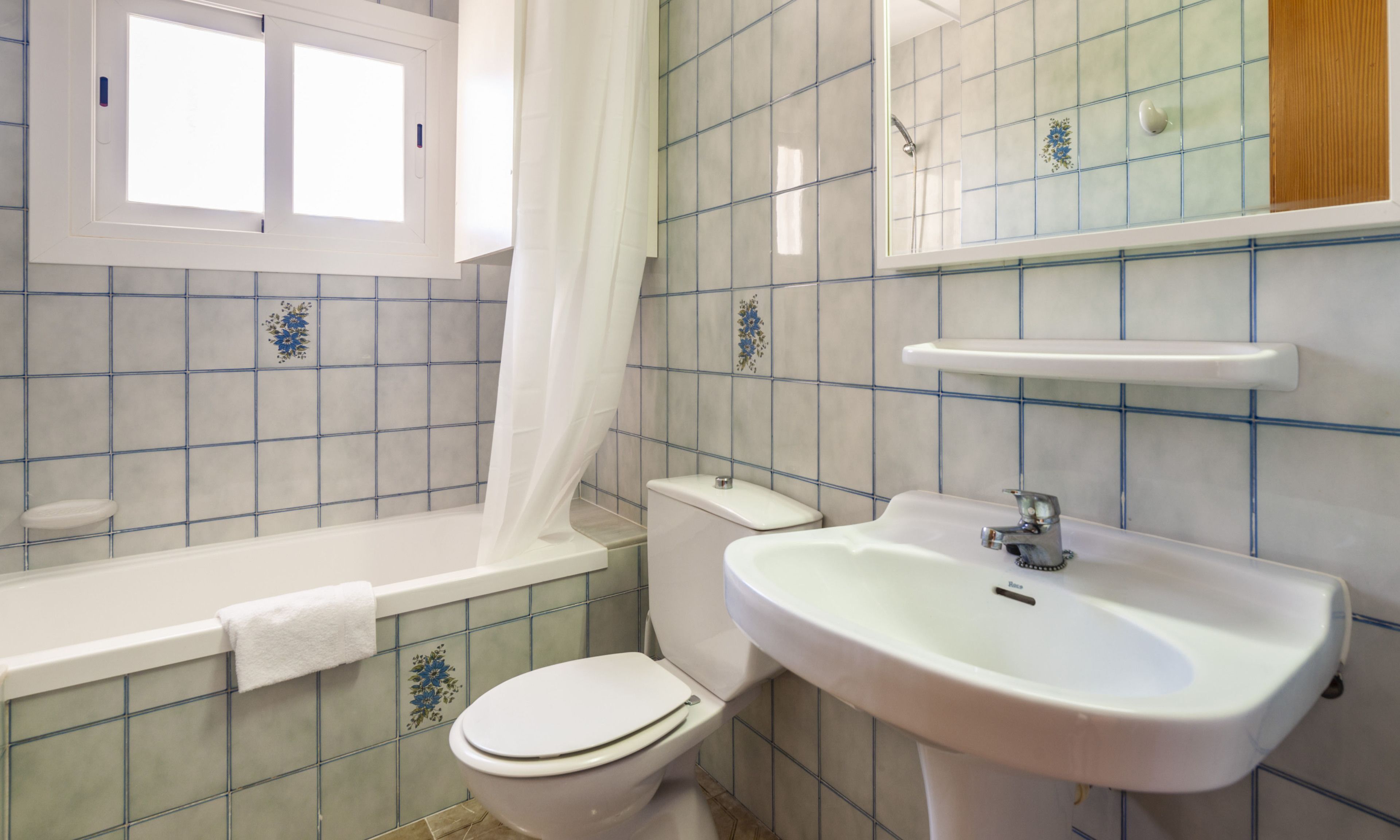 A bathroom with a toilet, sink, and bathtub.