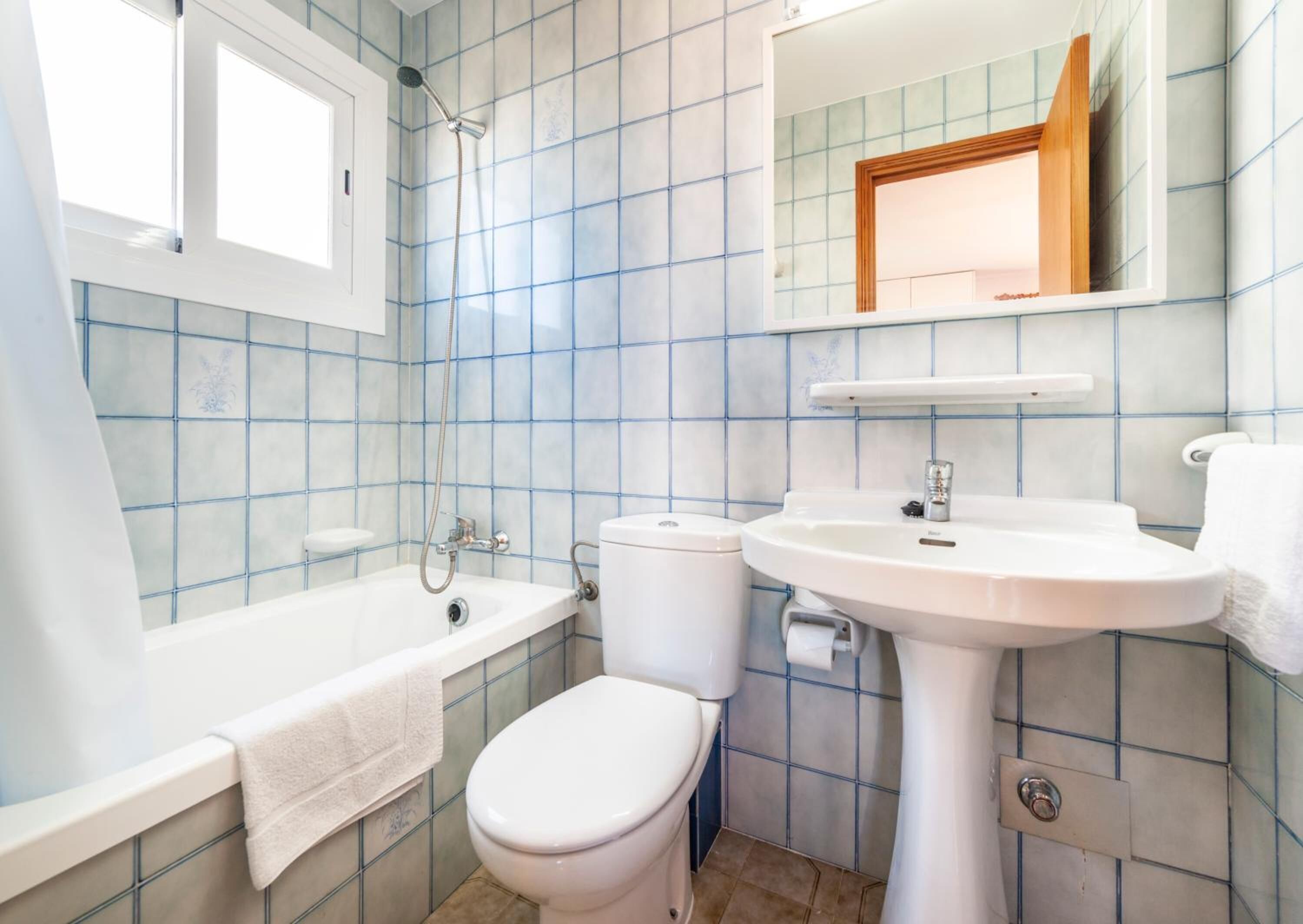 Un baño con bañera, inodoro y lavamanos.