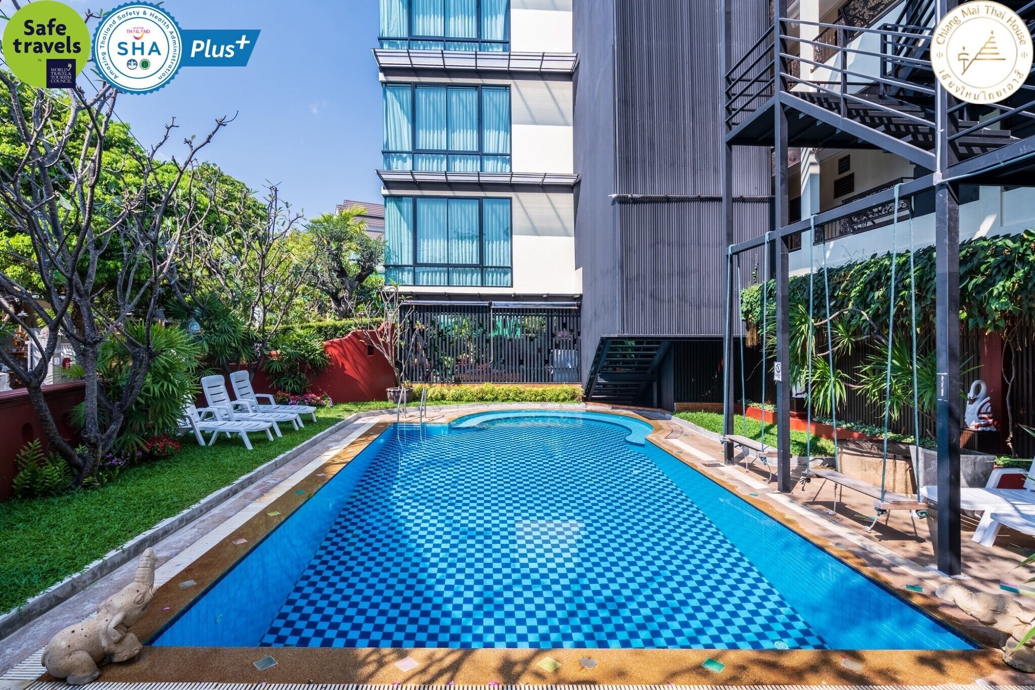 Una piscina al aire libre, sillones reclinables de piscina