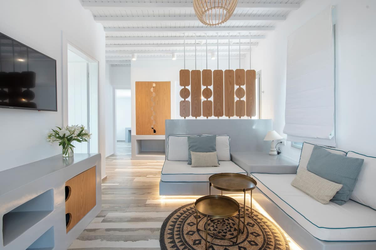 A modern living room with a sofa, coffee table, and decorative wall panel.