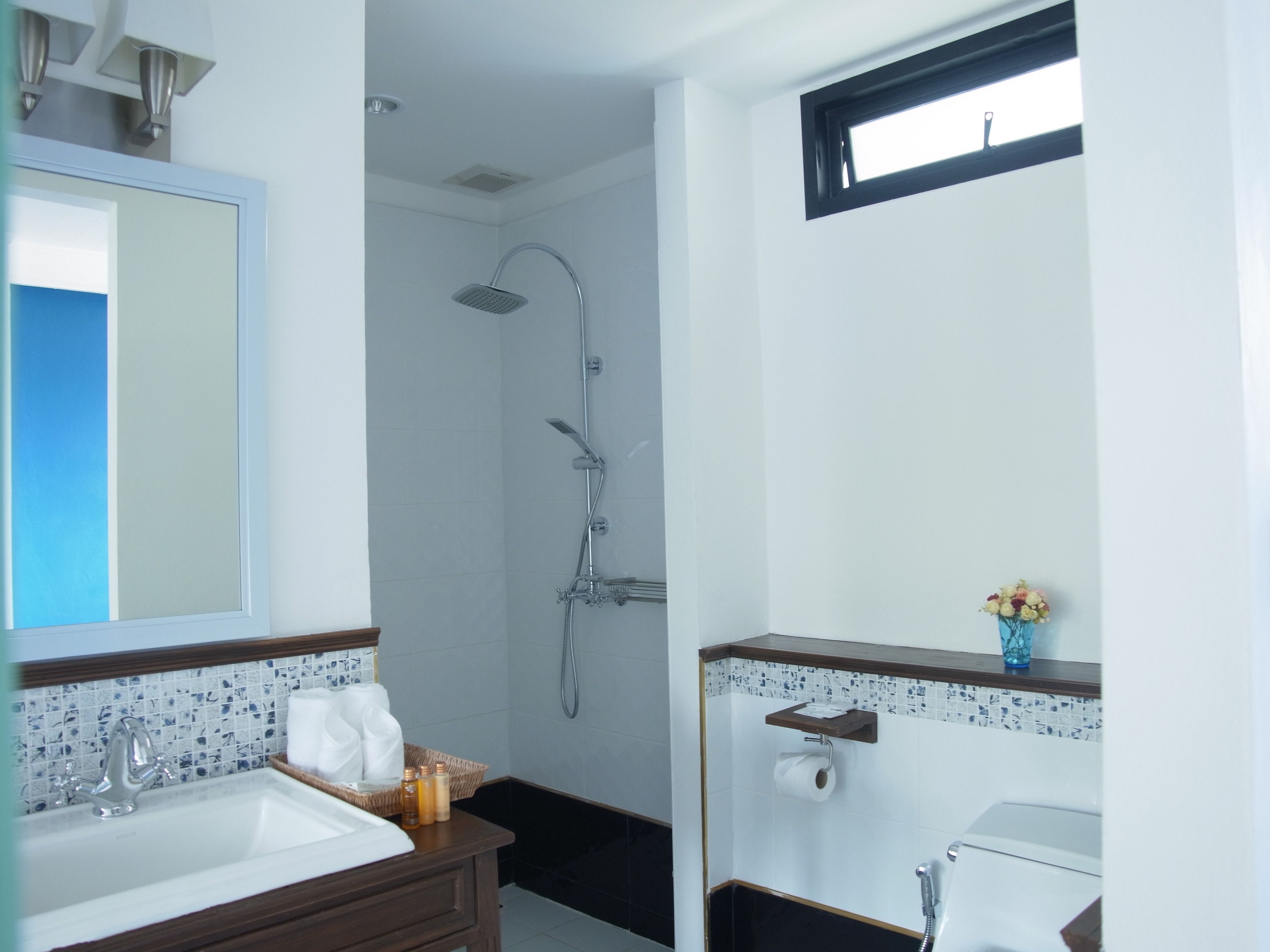Un baño moderno con ducha, lavamanos e inodoro.