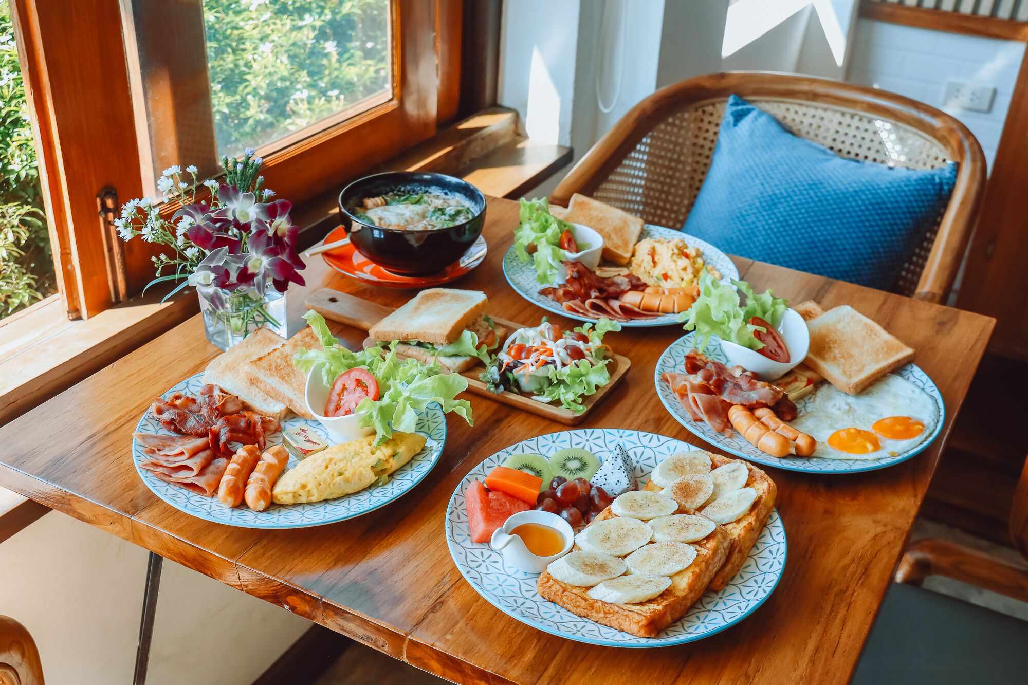 A breakfast table with various dishes including toast, eggs, bacon, and fruit.