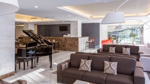 A modern lobby with a grand piano, comfortable seating, and a reception desk. - Steyler Fatima Hotel Congress (Ourem)