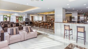 A spacious hotel lobby with a seating area, a piano, and a bar. - Steyler Fatima Hotel Congress (Ourem)