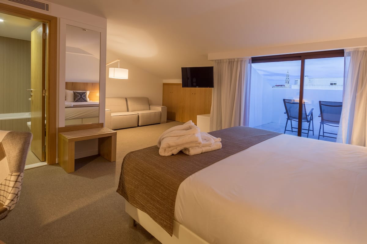 Junior suite, patio | Een minibar, een bureau, een laptopwerkplek, verduisterende gordijnen
