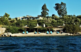 Ubicación a pie de playa, arena negra, sombrillas y toallas de playa