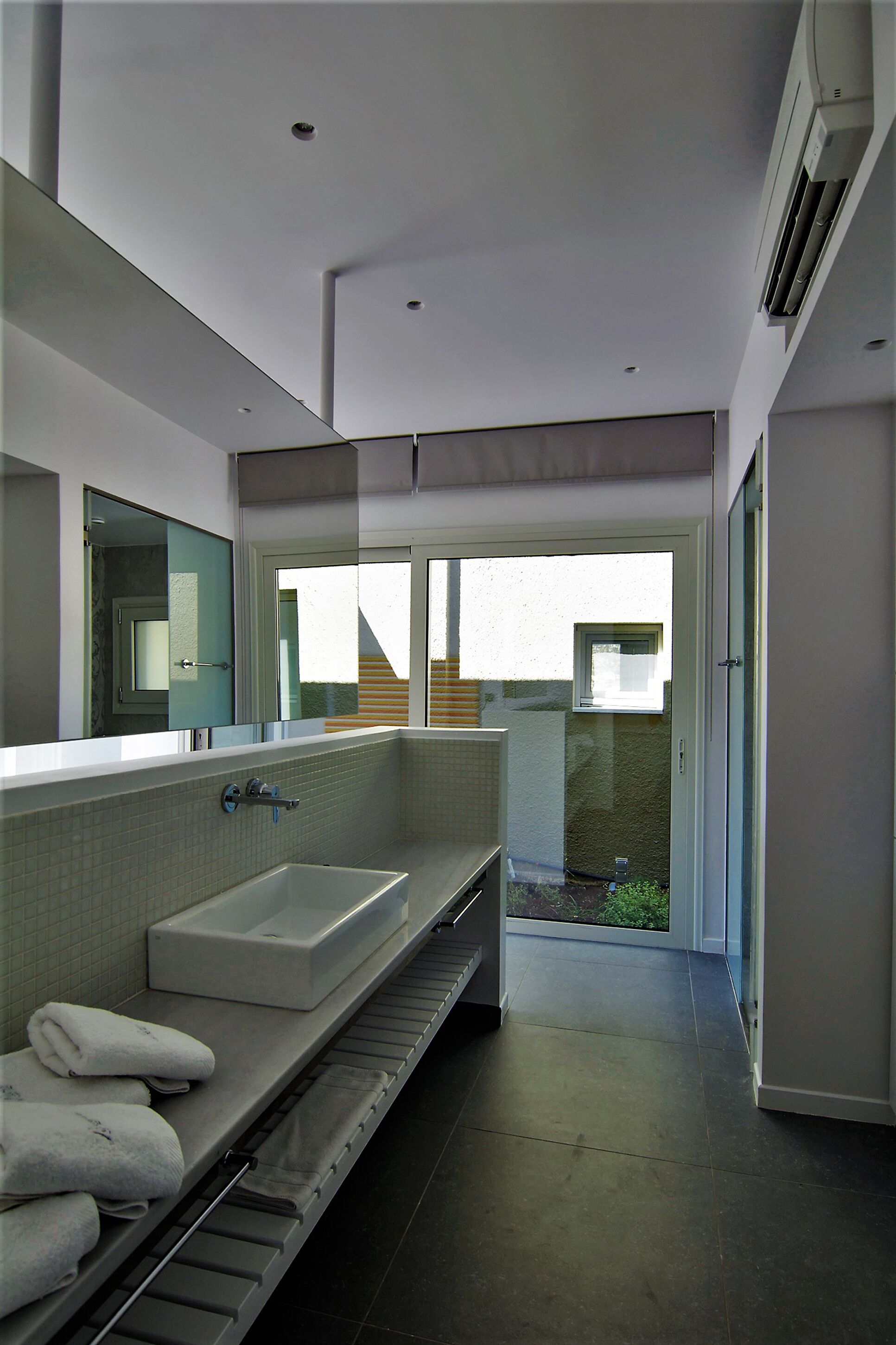 A modern bathroom with a large bathtub, a walk-in shower, and a glass-enclosed shower area.