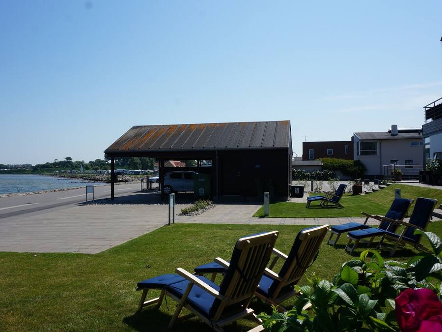 A waterfront patio with outdoor seating and a covered area.