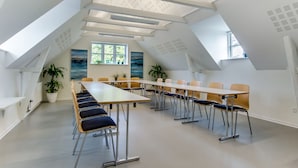 A modern conference room with a long table, multiple chairs, and potted plants. - Danhostel Kolding (Kolding)