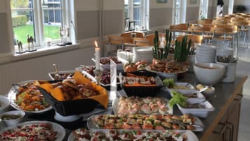 Ein Buffet mit verschiedenen Speisen und Blick durch große Fenster nach draußen.