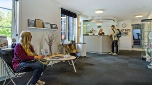A modern interior with a reception desk, seating area, and a visible clock. - Danhostel Kolding (Kolding)