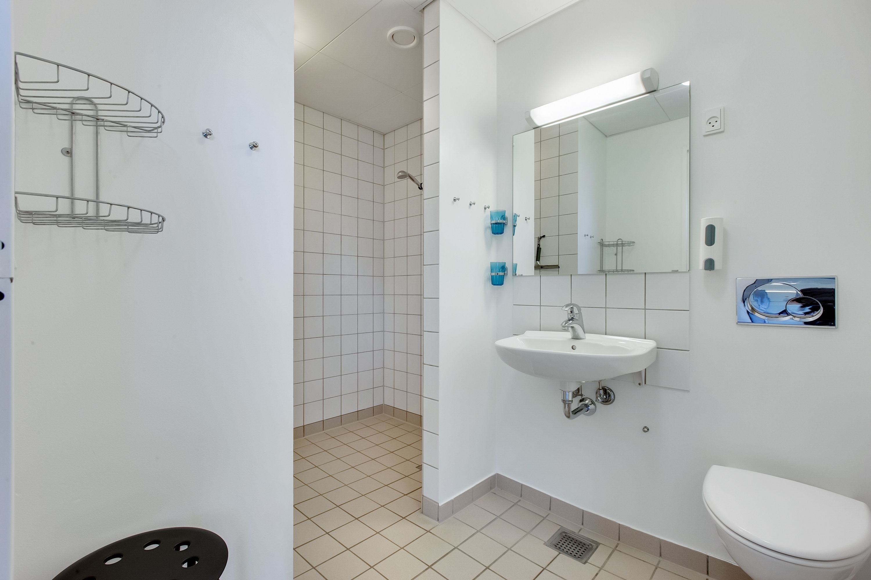 A modern bathroom with a white sink, mirror, and toilet.