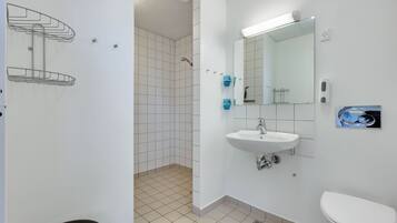 A modern bathroom with a white sink, mirror, and toilet.
