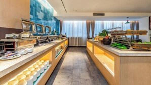 Un espace buffet doté de plusieurs points de service, d’un mur recouvert de carreaux et offrant une vue sur l’extérieur grâce à de grandes fenêtres.