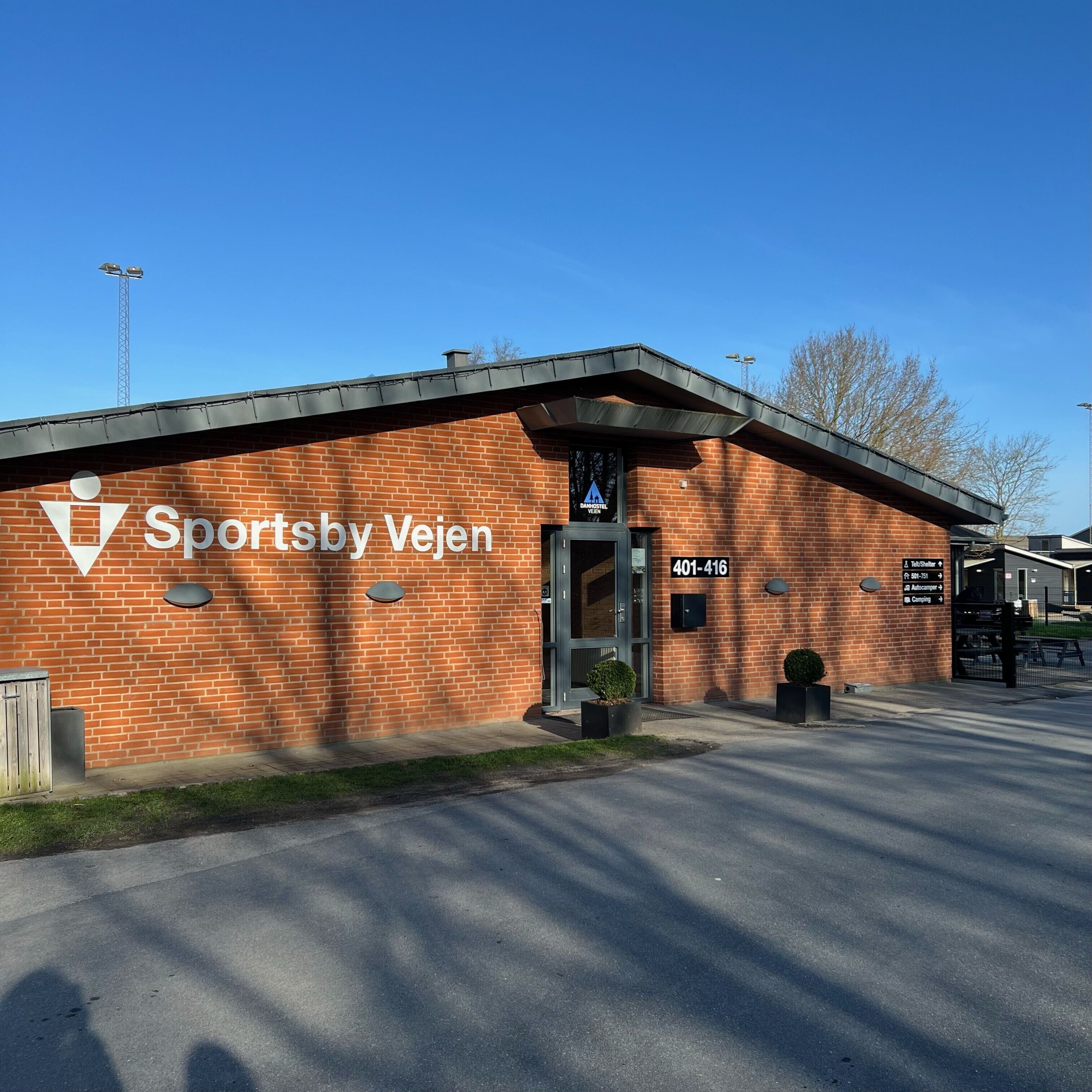 A brick building with a sign reading "Sportsby Vejen" and a phone number "401-416".