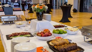 Een buffetopstelling met diverse gerechten en een decoratieve vaas.