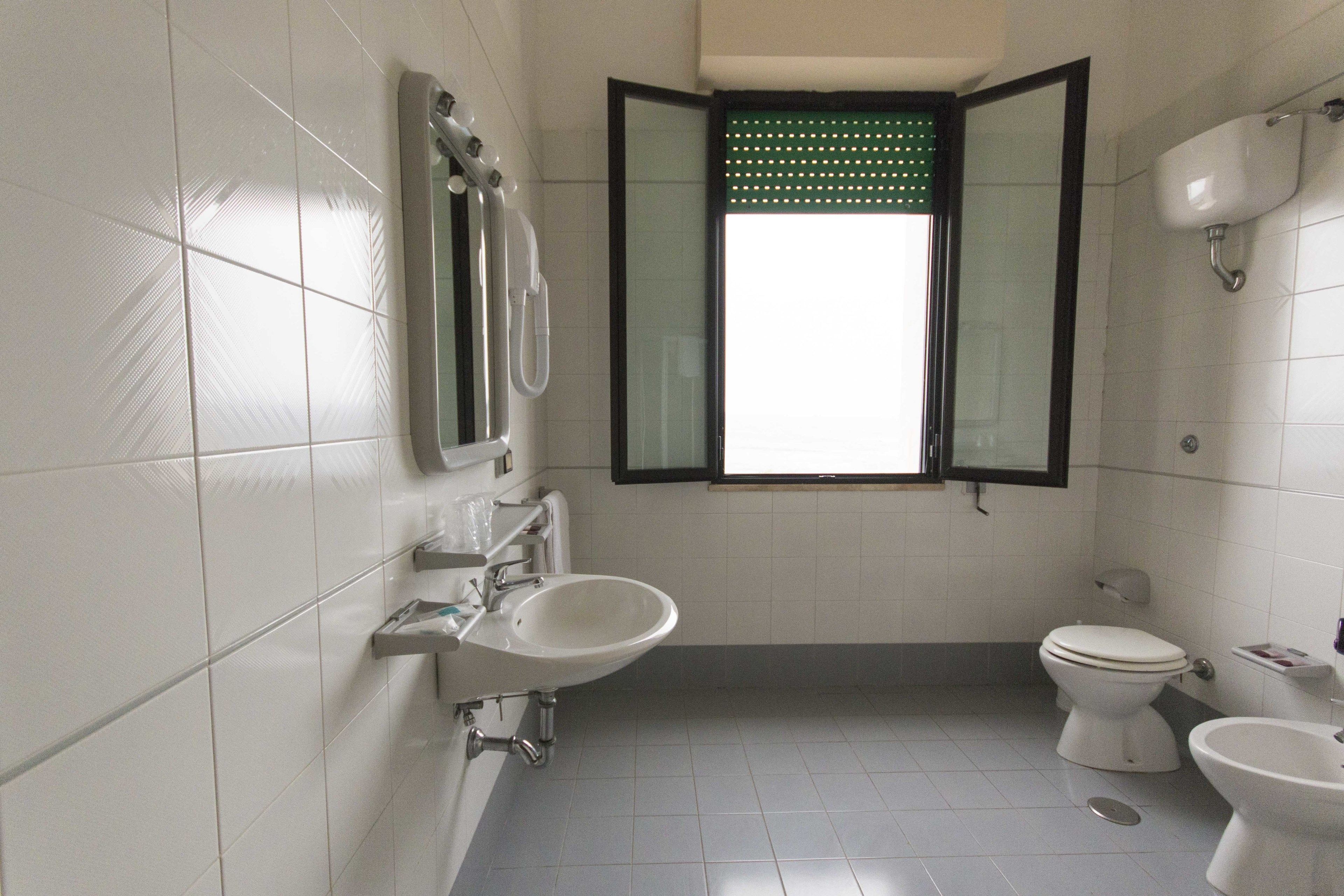 A bathroom with a toilet, bidet, and sink.