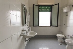 A bathroom with a toilet, bidet, and sink.