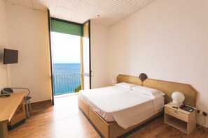 A bedroom with a bed, bedside table, and a desk. - Albergo Palazzo (Santa Cesarea Terme)