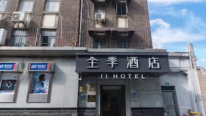En hotellentrén med en skylt som visar texten ”JI HOTEL” och en synlig dörr.