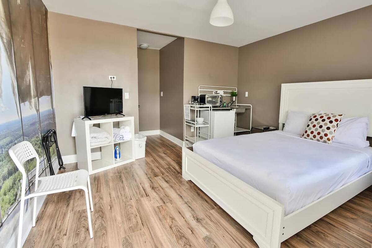 Una camera da letto con un letto, una TV, una scrivania e una sedia.