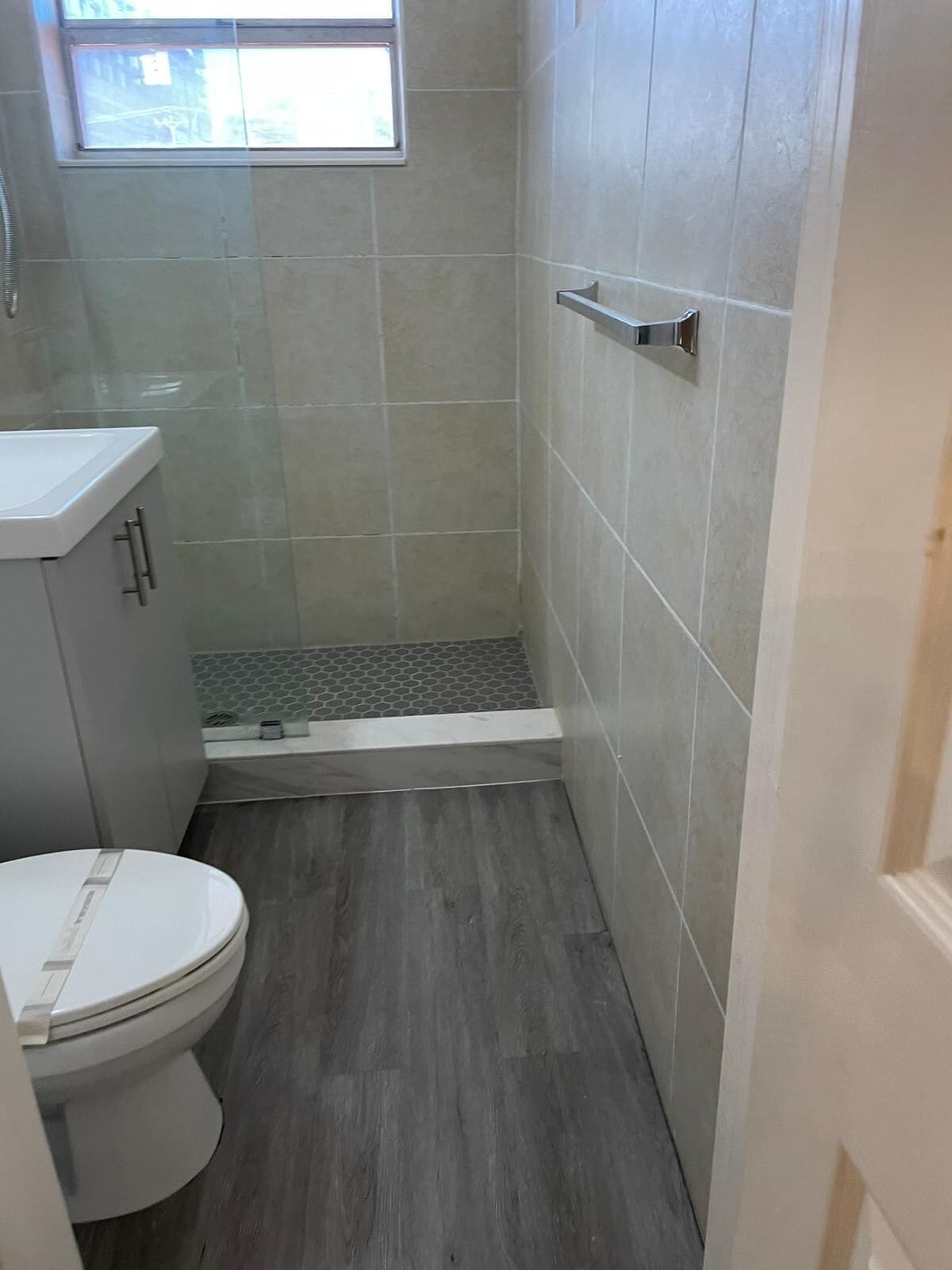 Un baño pequeño con inodoro, lavabo y zona de ducha.