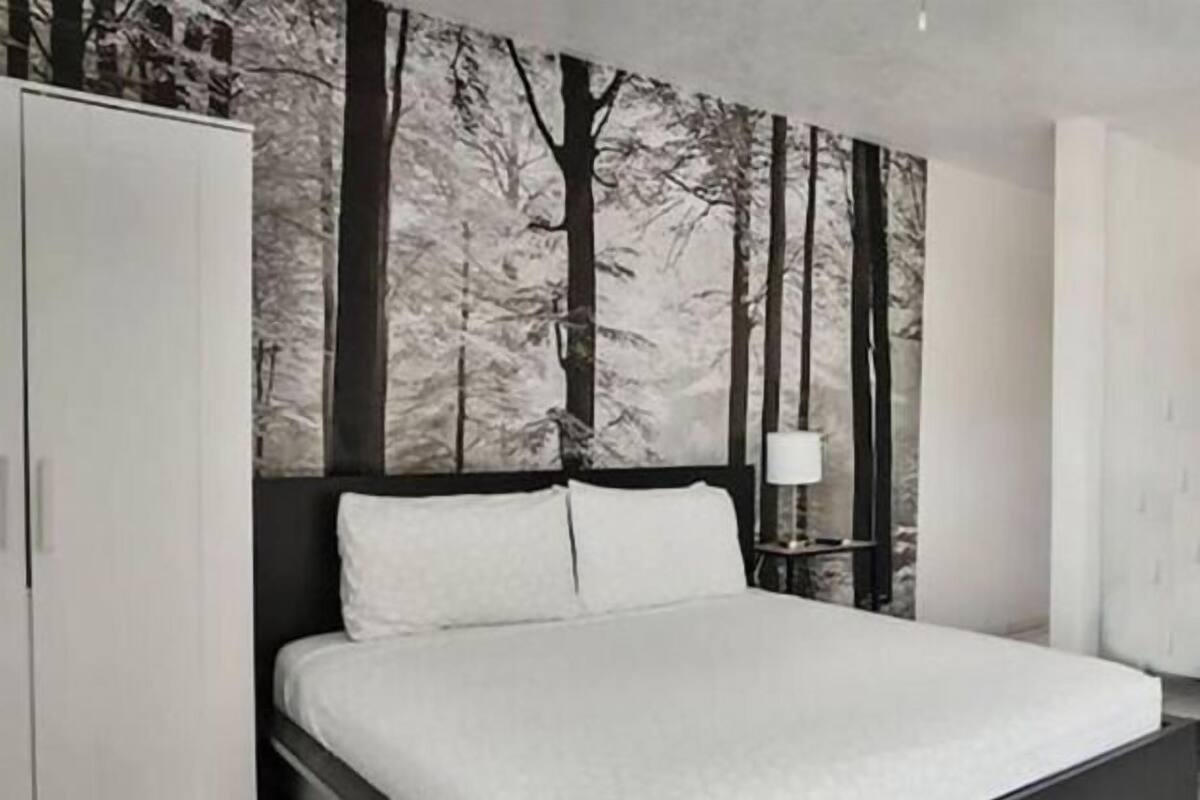 Una camera da letto moderna con un letto, un armadio e un affresco.