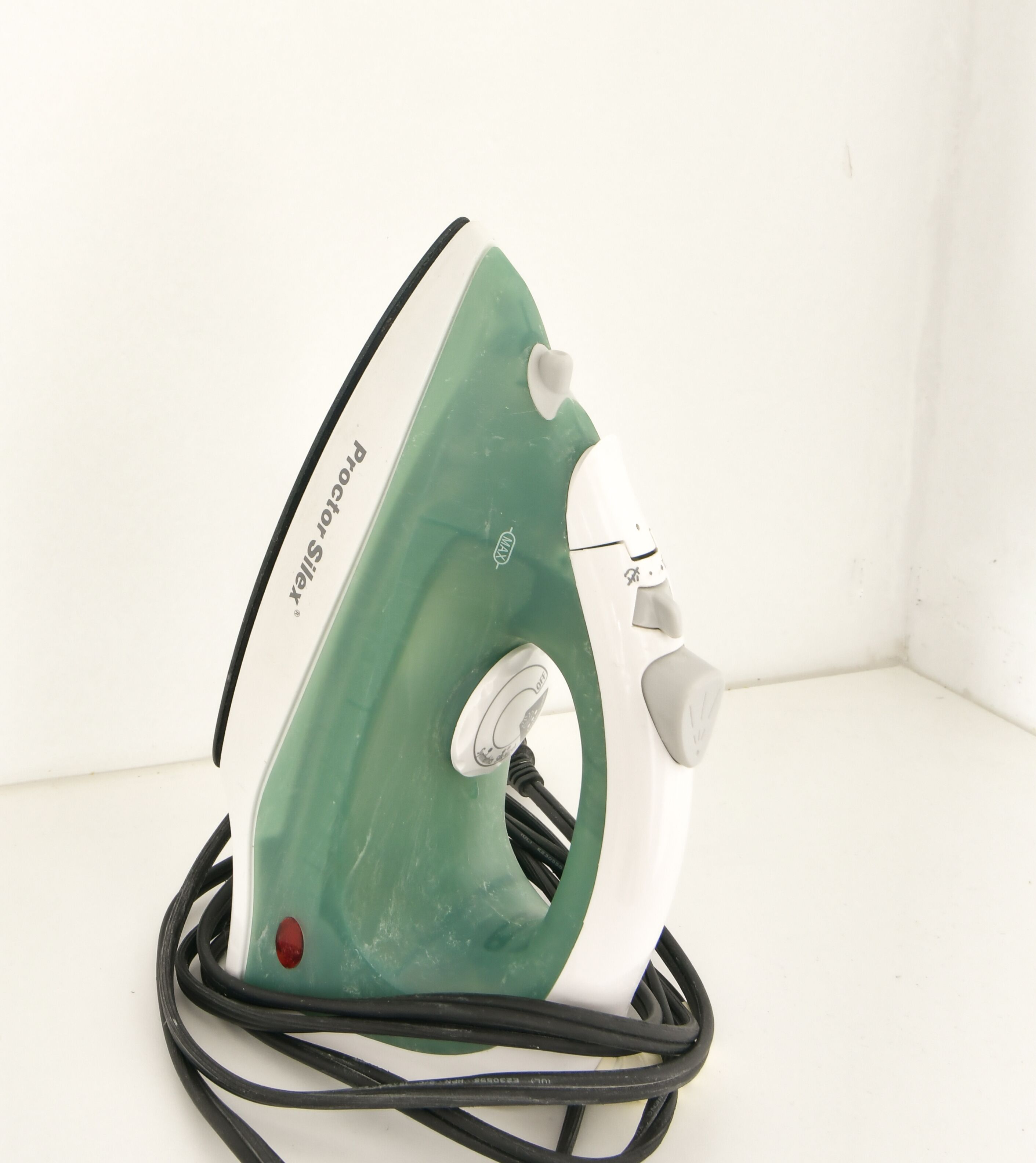 An iron with a green and white design, a control dial, and a power cord.