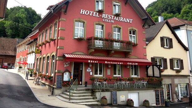 Un edificio rojo con un letrero que dice "HOTEL RESTAURANT COLLIN".