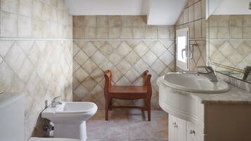 Un baño con inodoro, bidé y lavabo.