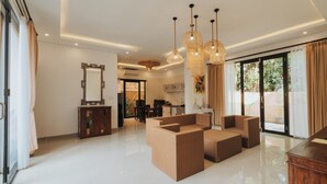A spacious living area with a large sofa set, a wooden cabinet, and a dining table. - Alam Penari Ubud (Ubud)