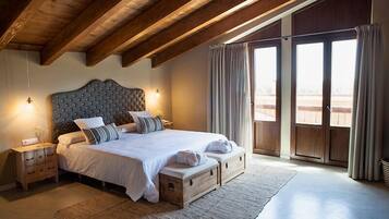 A bedroom with a large bed, wooden headboard, bedside tables, and a view through a sliding door.