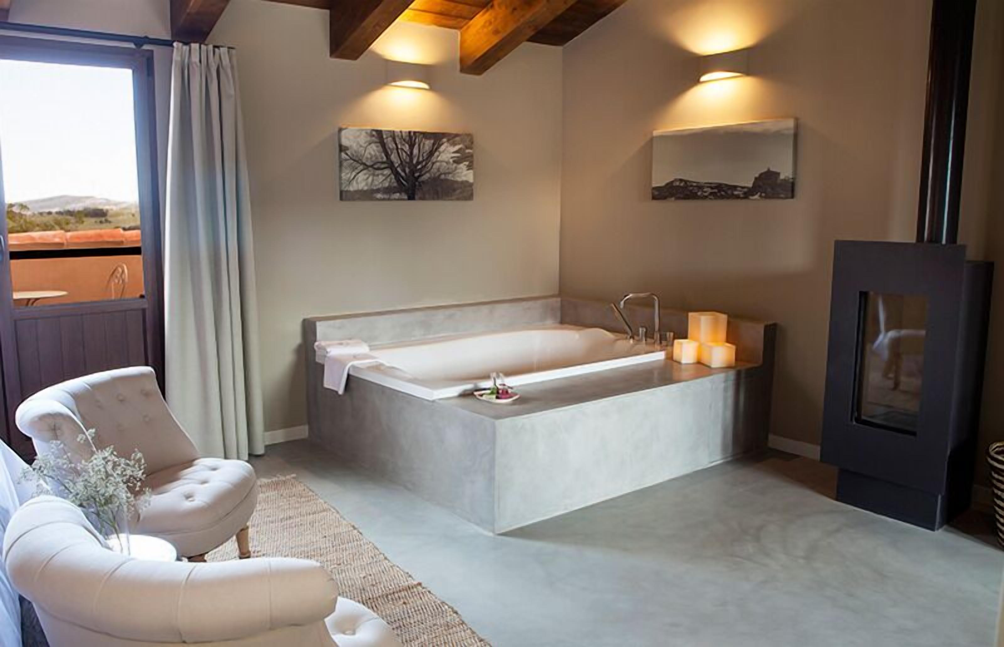A modern bathroom with a large bathtub, a wooden ceiling, and a view of the outdoors.