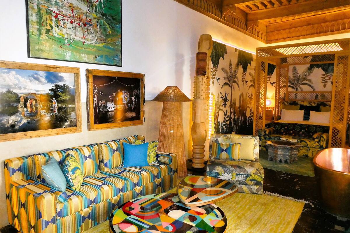 A cozy living room with a patterned sofa, a round coffee table, and a large abstract painting on the wall.