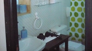 A bathroom with a sink, mirror, toilet, and a shower curtain with a polka dot pattern. - Hotel Castillo de Uña (Una)