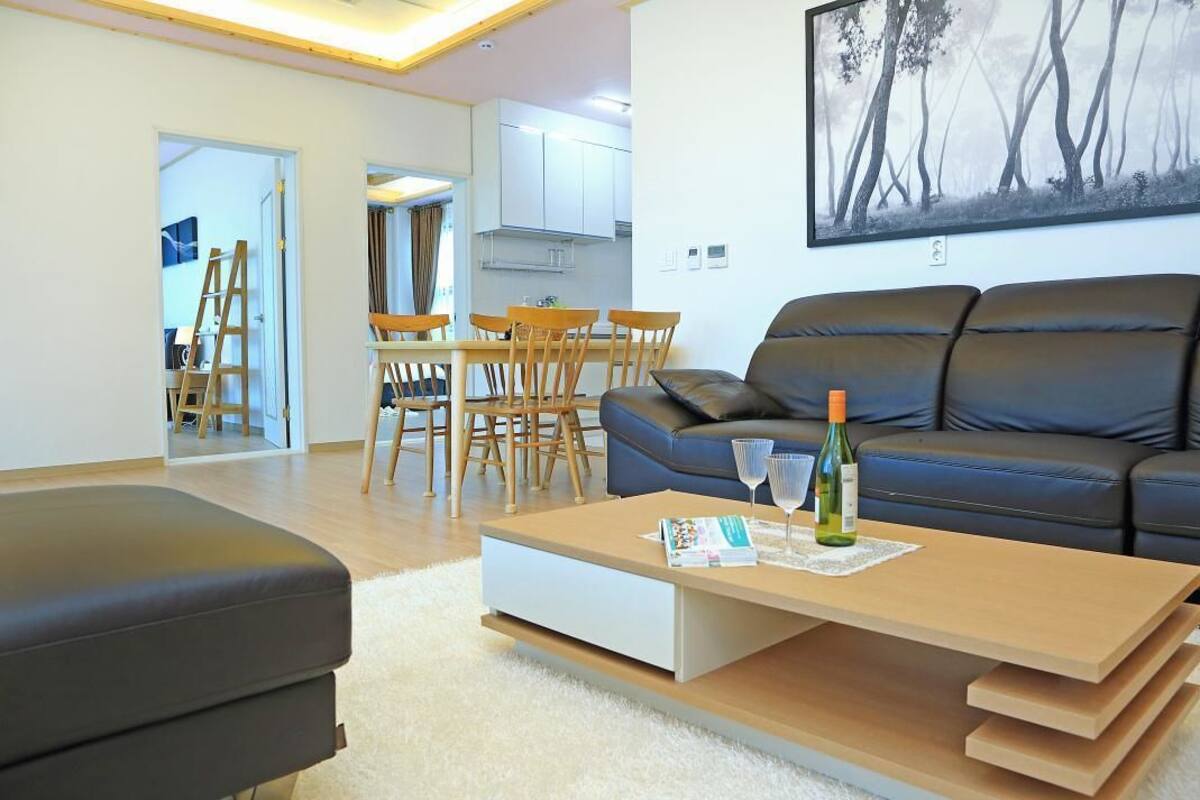 Un salon moderne comprenant un canapé, une table basse et un coin repas avec des chaises et une table.