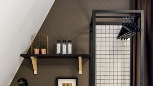 A modern kitchen with a black countertop, a coffee machine, mugs, and a framed picture of keys.