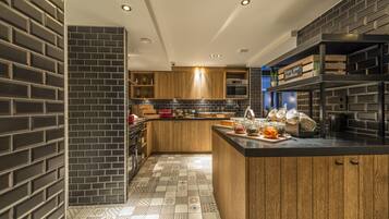 Una cocina moderna con una isla central, armarios de madera y un salpicadero negro.