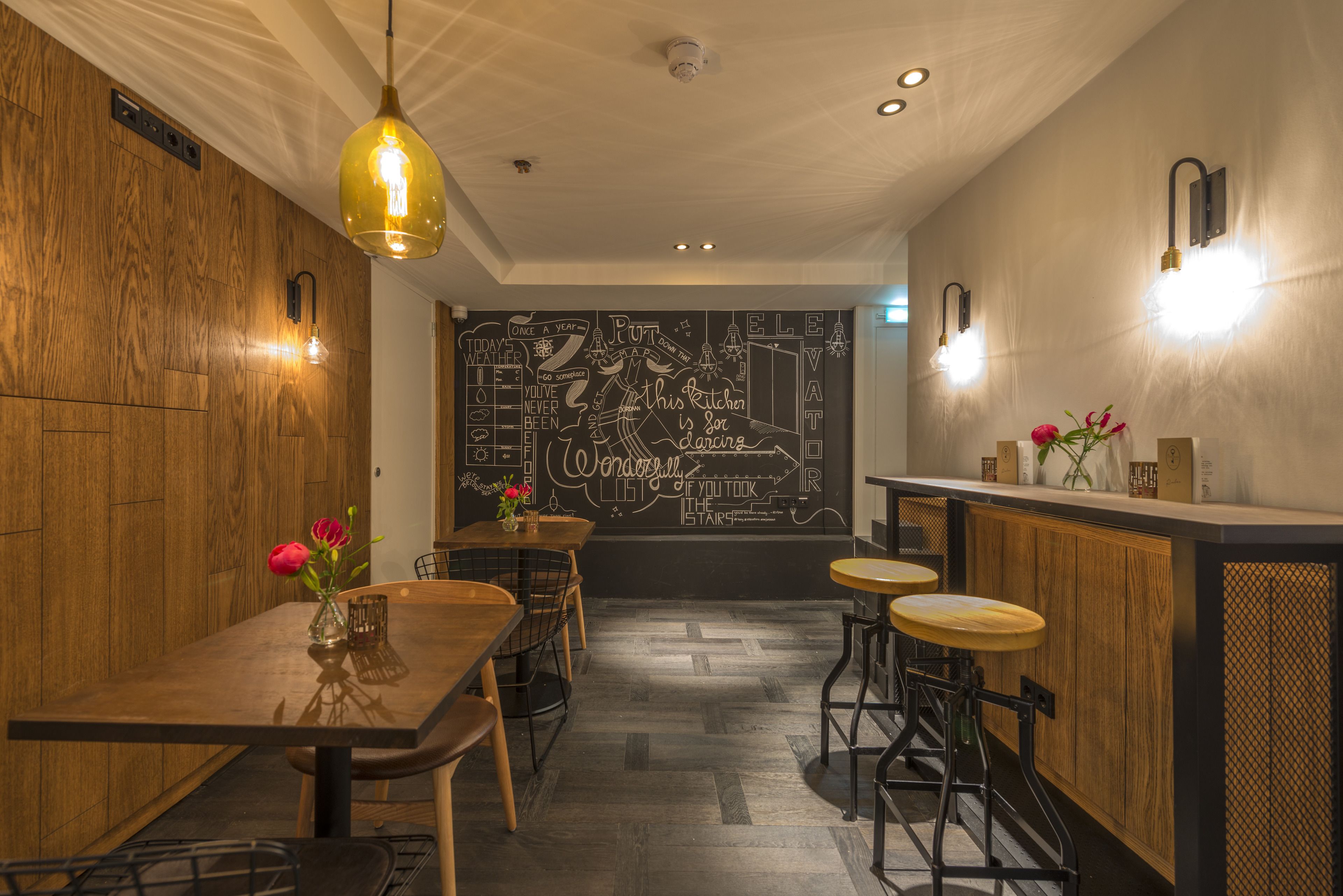 L’intérieur d’un restaurant avec des murs en bois, un menu écrit à la craie et des tabourets de bar.