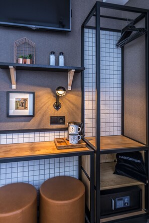 A modern bathroom with a black metal frame, a mirror, a towel rack, and a hairdryer in a cabinet. - Mr. Jordaan (Amsterdam)
