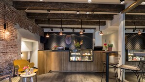 A cozy bar area with wooden furniture, a brick wall, and pendant lighting.